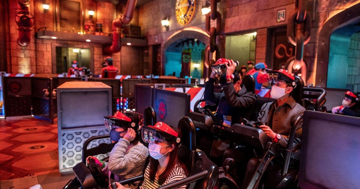 Universal Studios Japan visitors wear themed augmented reality goggles for the "Mario Kart" ride during a media preview of the Super Nintendo World at Universal Studios Japan in Osaka on March 17, 2021.